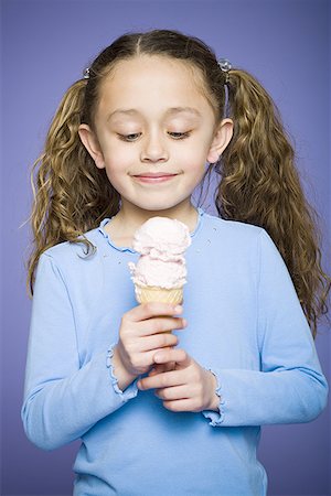 Close-up of a girl holding an ice cream cone Stock Photo - Premium Royalty-Free, Code: 640-01353930