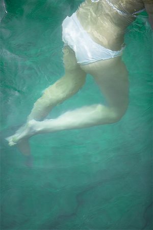 Low section view of a young woman swimming Stock Photo - Premium Royalty-Free, Code: 640-01364044