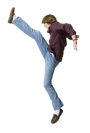 profile of boy jumping - Boy kicking leg up Stock Photo - Premium Royalty-Free, Code: 640-01364255