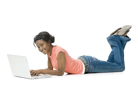 Portrait of a young woman lying on the floor using a laptop Stock Photo - Premium Royalty-Free, Code: 640-01364251