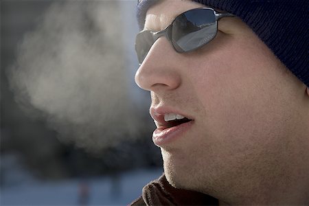 face close up young man looking sideways - Close-up of a young man outdoors in winter Stock Photo - Premium Royalty-Free, Code: 640-01364359