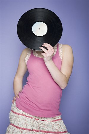people holding vinyl records - Close-up of a teenage girl covering her face with a record Stock Photo - Premium Royalty-Free, Code: 640-01364403