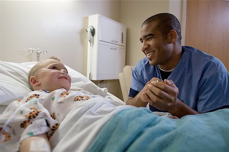 doctor with patient kids bed - Close-up of a male doctor consoling a boy Stock Photo - Premium Royalty-Free, Code: 640-01364436