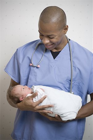 doctor examining boy baby - Male doctor carrying a new born baby Foto de stock - Sin royalties Premium, Código: 640-01364475