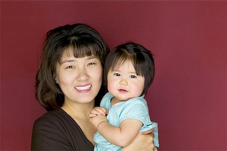 Portrait of a mother carrying her daughter Stock Photo - Premium Royalty-Free, Code: 640-01364834