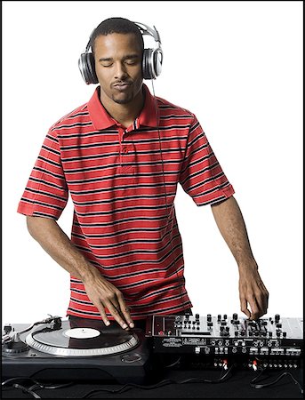 DJ with headphones spinning records Stock Photo - Premium Royalty-Free, Code: 640-01364913