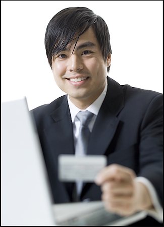 simsearch:400-04382597,k - Close-up of a businessman sitting in front of a laptop and holding a credit card Stock Photo - Premium Royalty-Free, Code: 640-01365007