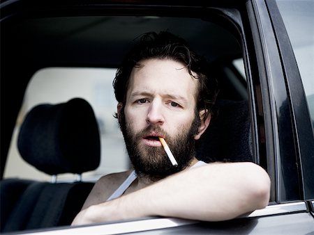 redneck facial hair - Man in car with cigarette hanging from mouth Stock Photo - Premium Royalty-Free, Code: 640-01365024