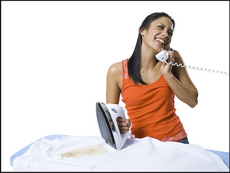 Distracted woman with iron and burned clothing Stock Photo - Premium Royalty-Free, Code: 640-01365037