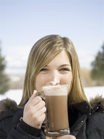 Portrait of a young woman drinking hot cocoa Stock Photo - Premium Royalty-Free, Code: 640-01365032