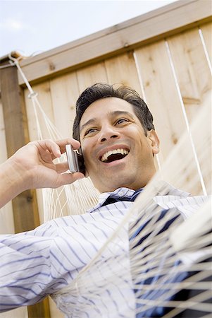 simsearch:640-02768119,k - Low angle view of a businessman talking on the mobile phone Fotografie stock - Premium Royalty-Free, Codice: 640-01365210