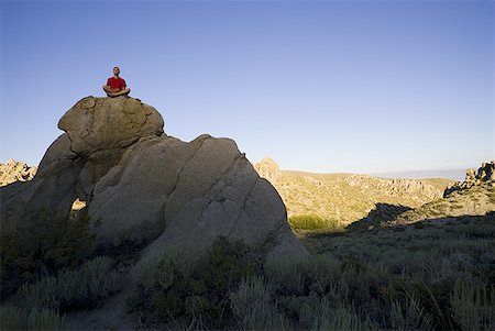 simsearch:640-02775063,k - Person sitting on large rock outdoors doing yoga Foto de stock - Sin royalties Premium, Código: 640-01365253