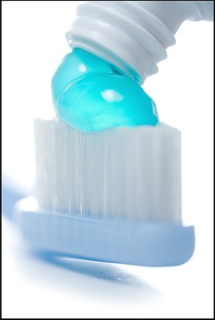 Close-up of toothpaste flowing out of a tube on the bristles of a toothbrush Stock Photo - Premium Royalty-Free, Code: 640-01365269