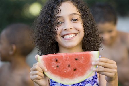 simsearch:640-01365502,k - Portrait d'une jeune fille tenant une pastèque et souriant Photographie de stock - Premium Libres de Droits, Code: 640-01365385