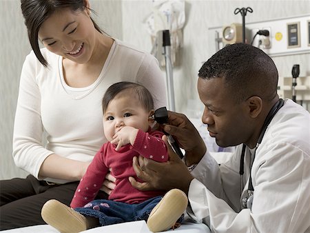 doctor office group - Profile of a male doctor examining a baby Stock Photo - Premium Royalty-Free, Code: 640-01365523