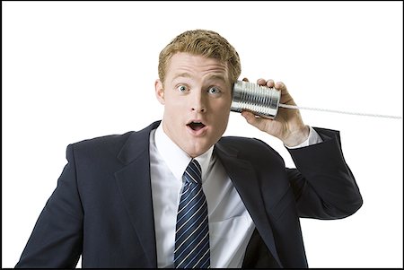 suit business man close up face one person only - Portrait of a businessman using a tin can phone Stock Photo - Premium Royalty-Free, Code: 640-01365541