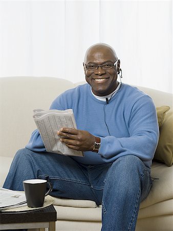 A man holding a newspaper and smiling Stock Photo - Premium Royalty-Free, Code: 640-01365692