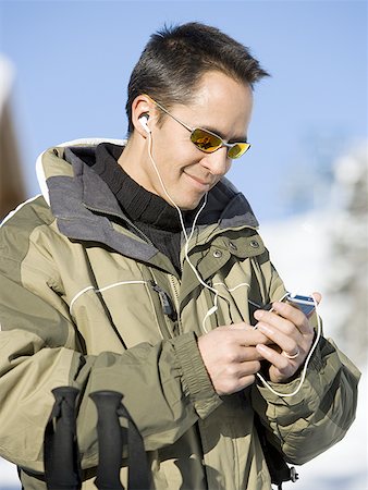 simsearch:640-02772872,k - Homme à l'extérieur en hiver avec lecteur mp3 souriant Photographie de stock - Premium Libres de Droits, Code: 640-01365736