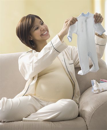 simsearch:640-02658367,k - Pregnant woman looking at baby clothes Fotografie stock - Premium Royalty-Free, Codice: 640-01365974