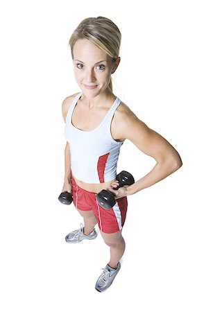 sweaty look of determination - High angle view of a young woman holding dumbbells Stock Photo - Premium Royalty-Free, Code: 640-01365995