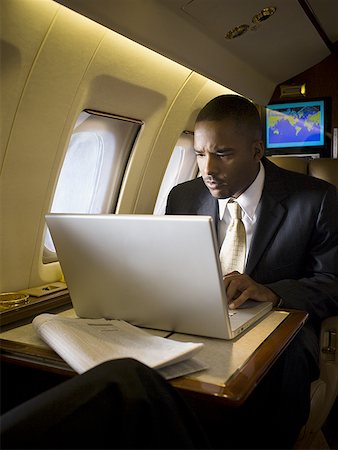 Homme d'affaires à l'aide d'un ordinateur portable dans un avion Photographie de stock - Premium Libres de Droits, Code: 640-01366014