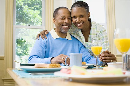 Portrait of a woman and a  man smiling at the breakfast table Stock Photo - Premium Royalty-Free, Code: 640-01366149