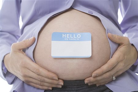 Mid section view of a pregnant woman with a name tag on her abdomen Stock Photo - Premium Royalty-Free, Code: 640-01366187