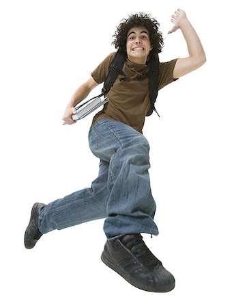 Portrait of a teenage boy making a face and jumping in mid-air Stock Photo - Premium Royalty-Free, Code: 640-01366246