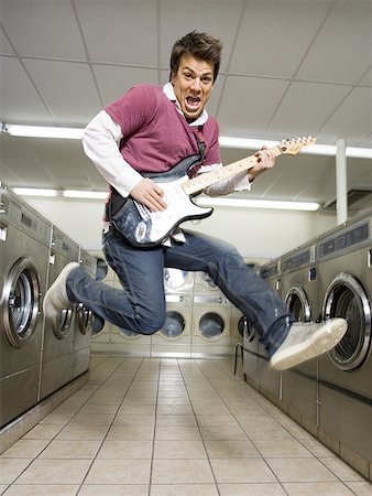 Man playing electric guitar at Laundromat Stock Photo - Premium Royalty-Free, Code: 640-01366379