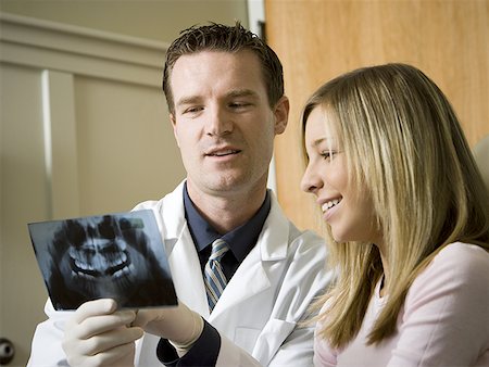 Dentist looking at x-rays with girl Stock Photo - Premium Royalty-Free, Code: 640-01366387