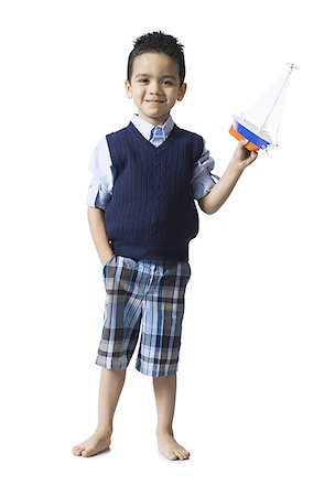 Boy holding toy boat Foto de stock - Sin royalties Premium, Código: 640-01366454