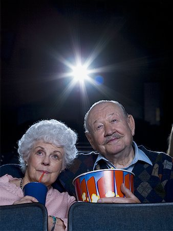 Man and woman watching movie with popcorn Stock Photo - Premium Royalty-Free, Code: 640-01366510