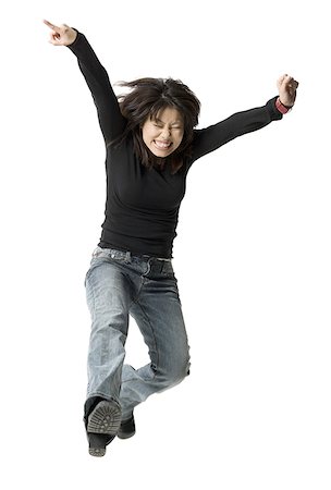 Low angle view of a mid adult woman jumping with her arms raised Stock Photo - Premium Royalty-Free, Code: 640-01366545