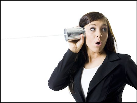 Close-up of a teenage girl holding a tin can phone up to her ear Fotografie stock - Premium Royalty-Free, Codice: 640-01366542