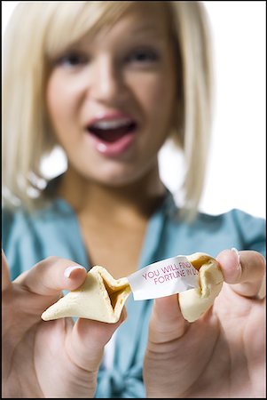Woman opening fortune cookie Foto de stock - Royalty Free Premium, Número: 640-01366587
