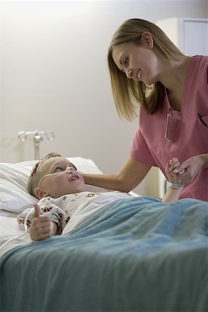 Female doctor talking to a boy lying on the bed Stock Photo - Premium Royalty-Free, Code: 640-01360002