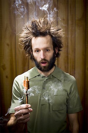 electricity humor - Man with smoking hair and electrical plug Stock Photo - Premium Royalty-Free, Code: 640-01360101