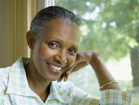 elderly black woman indoors - Portrait of a senior woman smiling Stock Photo - Premium Royalty-Free, Code: 640-01360102