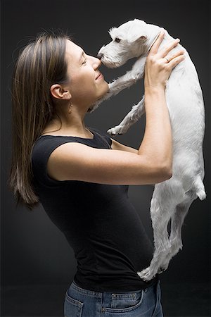 Profile of a young woman playing with her dog Stock Photo - Premium Royalty-Free, Code: 640-01360121