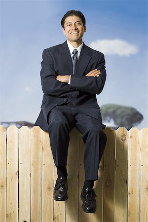 simsearch:640-02771261,k - Businessman sitting on fence smiling Stock Photo - Premium Royalty-Free, Code: 640-01360226