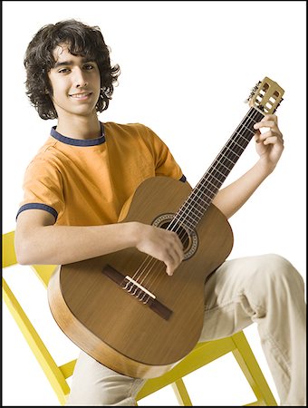 simsearch:640-02766814,k - Portrait of a teenage boy playing the guitar Fotografie stock - Premium Royalty-Free, Codice: 640-01360291