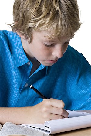 Close-up of a boy writing on a note pad Stock Photo - Premium Royalty-Free, Code: 640-01360312