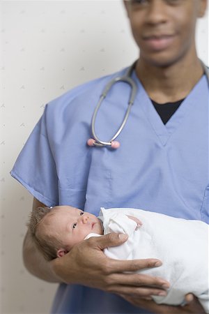 simsearch:640-01352922,k - Male doctor carrying a new born baby Foto de stock - Royalty Free Premium, Número: 640-01360334