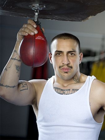 saco de arena (boxeo) - Portrait of a young man holding a punching bag Foto de stock - Sin royalties Premium, Código: 640-01360342