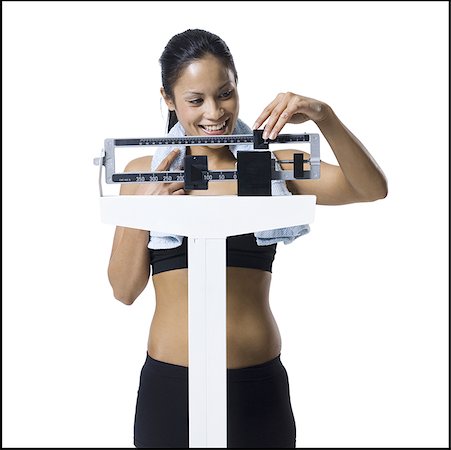 Woman weighing herself on scale Stock Photo - Premium Royalty-Free, Code: 640-01360356