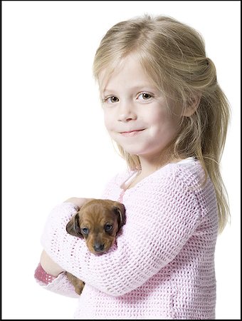 dog person white background - Portrait of a girl holding a dachshund puppy Stock Photo - Premium Royalty-Free, Code: 640-01360350