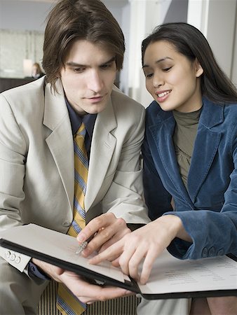 simsearch:640-01348337,k - Close-up of a young man and a young woman sitting looking at a file Fotografie stock - Premium Royalty-Free, Codice: 640-01360433