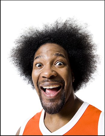 funny faces african american - Basketball player with an afro in orange uniform Stock Photo - Premium Royalty-Free, Code: 640-01360476