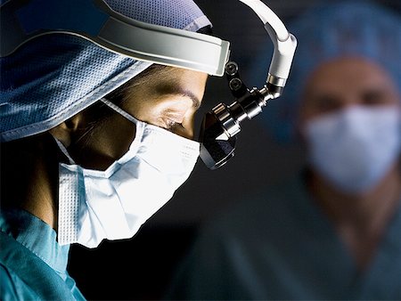 Female doctor in scrubs with head light in surgery Stock Photo - Premium Royalty-Free, Code: 640-01360497
