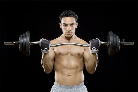 Portrait of a mid adult man lifting a barbell Stock Photo - Premium Royalty-Free, Code: 640-01360807
